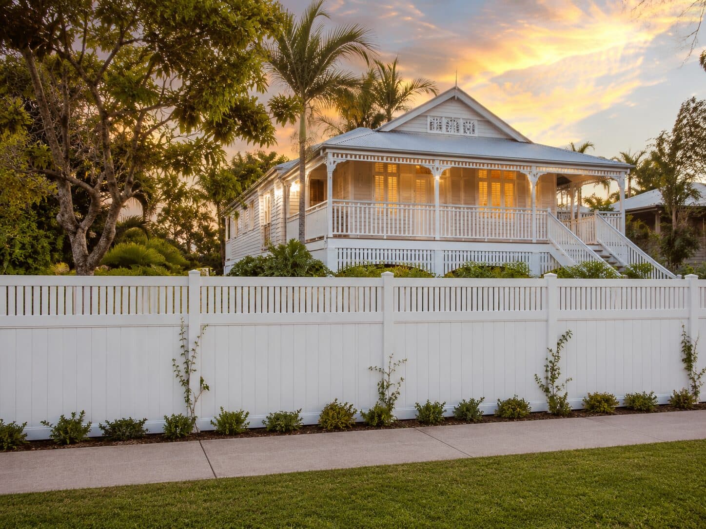 Eton closed-top PVC fencing along a classic golden-hour Queenslander front frontage.
